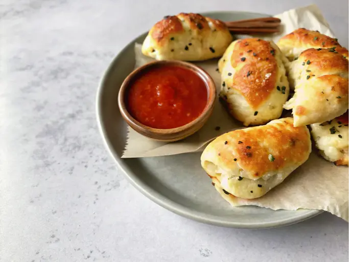 A baking tray filled with rows of freshly baked Greek yogurt garlic bread.