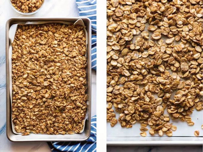 A baking sheet filled with a raw mixture of oats, nuts, and other granola ingredients, ready to be baked.
