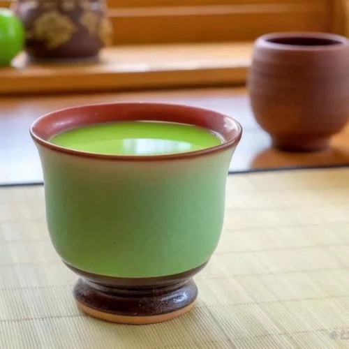 Japanese Mounjaro Recipe – The Ultimate Guide to Flavorful Wellness 5 Ceramic cup of matcha green tea on a bamboo mat near a green apple